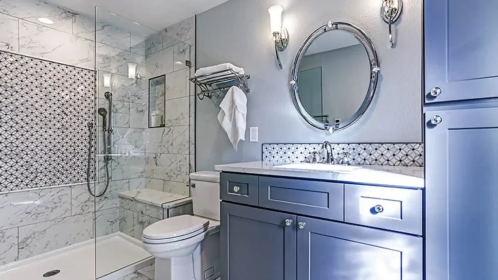 Modern bathroom with marble tile shower, geometric accent wall, blue vanity cabinet and chrome fixtures - Concord's Handyman Crew bathroom renovation services in Concord NC