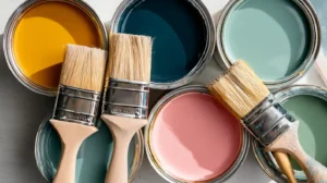 Open paint cans in multiple colors with natural‑bristle brushes ready for an interior or exterior repaint project. Interior and exterior painting in Concord NC showing Concord’s Handyman Crew painting services