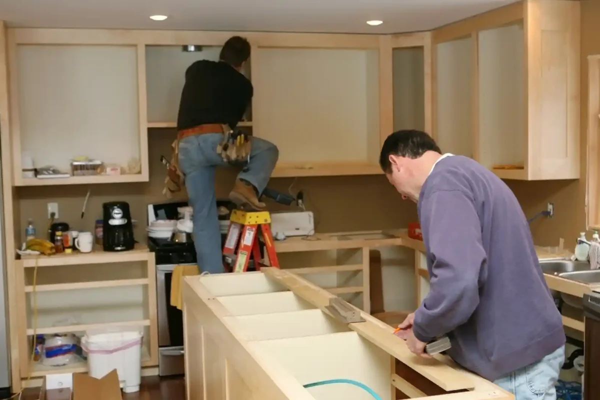 Professional handymen installing custom kitchen cabinets during renovation project - Concord's Handyman Crew kitchen remodeling services in Concord NC